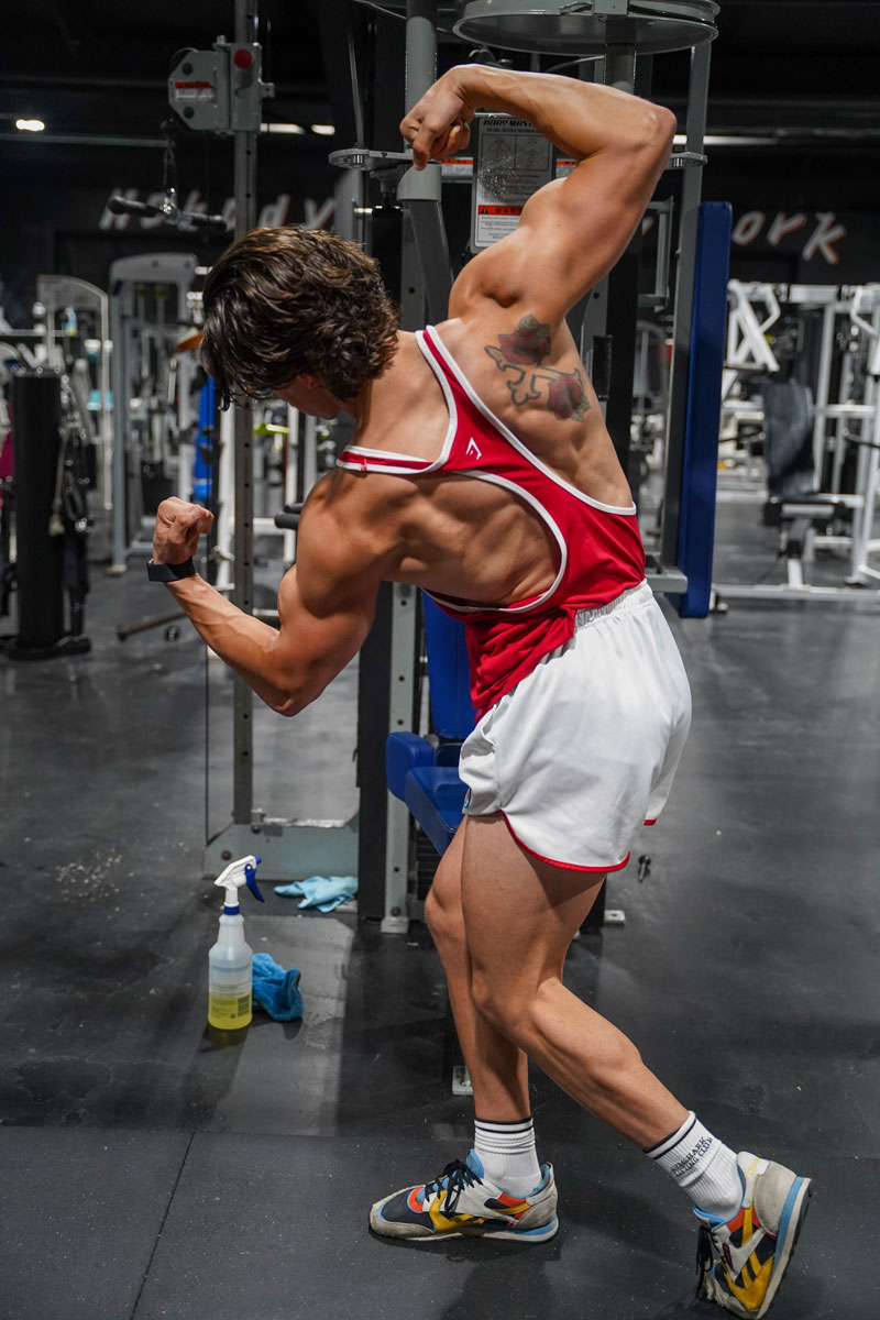 The coach is showing his back muscle.